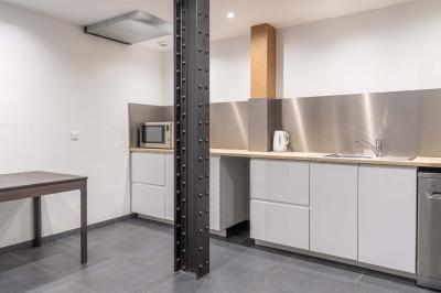 Salle de bain moderne avec murs et sols en finition bois, lavabo collectif et éclairage encastré.