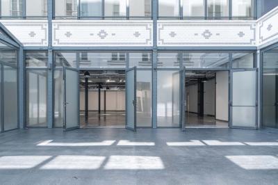 Salle de bain moderne avec murs et sols en finition bois, lavabo collectif et éclairage encastré.