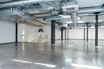 Salle de bain moderne avec murs et sols en finition bois, lavabo collectif et éclairage encastré.