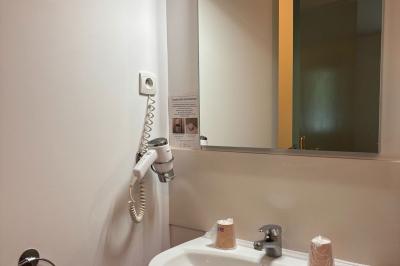 Viande en cuisson sur une broche au-dessus d'un barbecue en plein air, dans un jardin verdoyant.