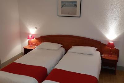 Viande en cuisson sur une broche au-dessus d'un barbecue en plein air, dans un jardin verdoyant.