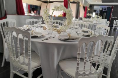 Viande en cuisson sur une broche au-dessus d'un barbecue en plein air, dans un jardin verdoyant.