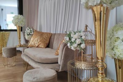 Viande en cuisson sur une broche au-dessus d'un barbecue en plein air, dans un jardin verdoyant.