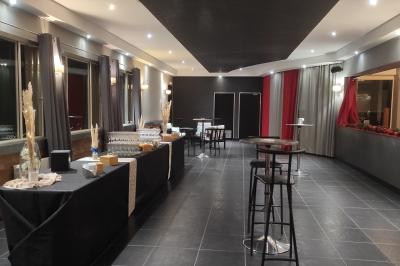 Viande en cuisson sur une broche au-dessus d'un barbecue en plein air, dans un jardin verdoyant.