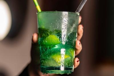 Salle de restaurant avec des tables dressées, des chaises en cuir marron et une enseigne murale ’LA CASA’.