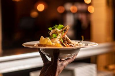 Salle de restaurant avec des tables dressées, des chaises en cuir marron et une enseigne murale ’LA CASA’.