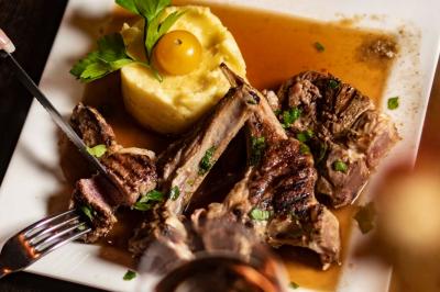 Salle de restaurant avec des tables dressées, des chaises en cuir marron et une enseigne murale ’LA CASA’.