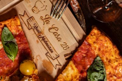 Salle de restaurant avec des tables dressées, des chaises en cuir marron et une enseigne murale ’LA CASA’.