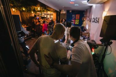 Salle de restaurant avec des tables dressées, des chaises en cuir marron et une enseigne murale ’LA CASA’.
