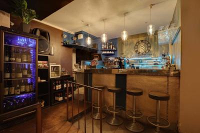 Salle de restaurant avec des tables dressées, des chaises en cuir marron et une enseigne murale ’LA CASA’.