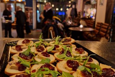 Salle de restaurant avec des tables dressées, des chaises en cuir marron et une enseigne murale ’LA CASA’.