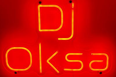 Main ajustant les réglages sur une table de mixage DJ avec des lumières colorées et un ordinateur portable à proximité.