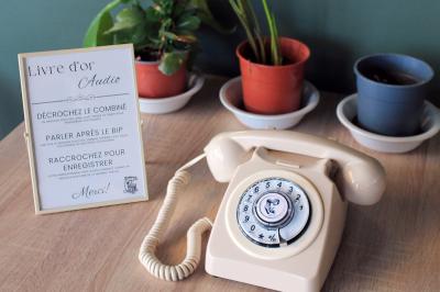 Photo d'un téléphone rouge rétro, un disque vinyle noir, un disque rouge en forme de cœur et une photo de mariage.