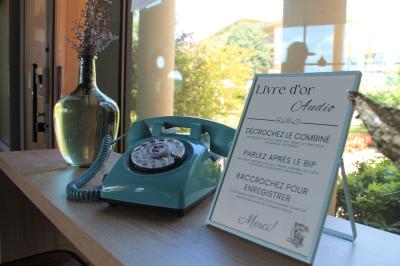 Photo d'un téléphone rouge rétro, un disque vinyle noir, un disque rouge en forme de cœur et une photo de mariage.