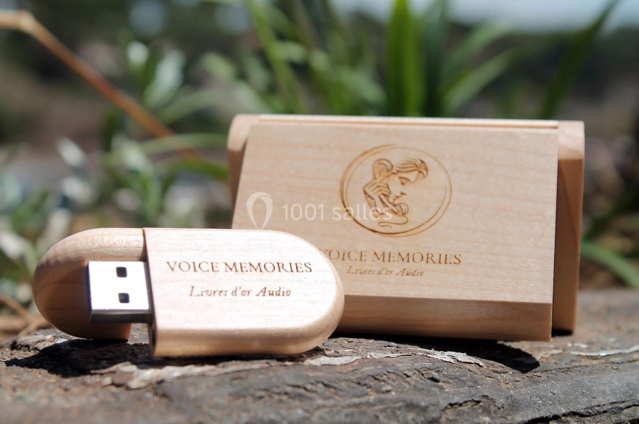 Clé USB en bois gravée avec son étui assorti, posée sur une surface naturelle avec un arrière-plan végétal.