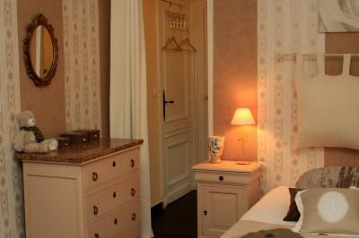 Décoration de table de réception avec nappes blanches, chandeliers, vaisselle élégante et arrangement floral blanc.