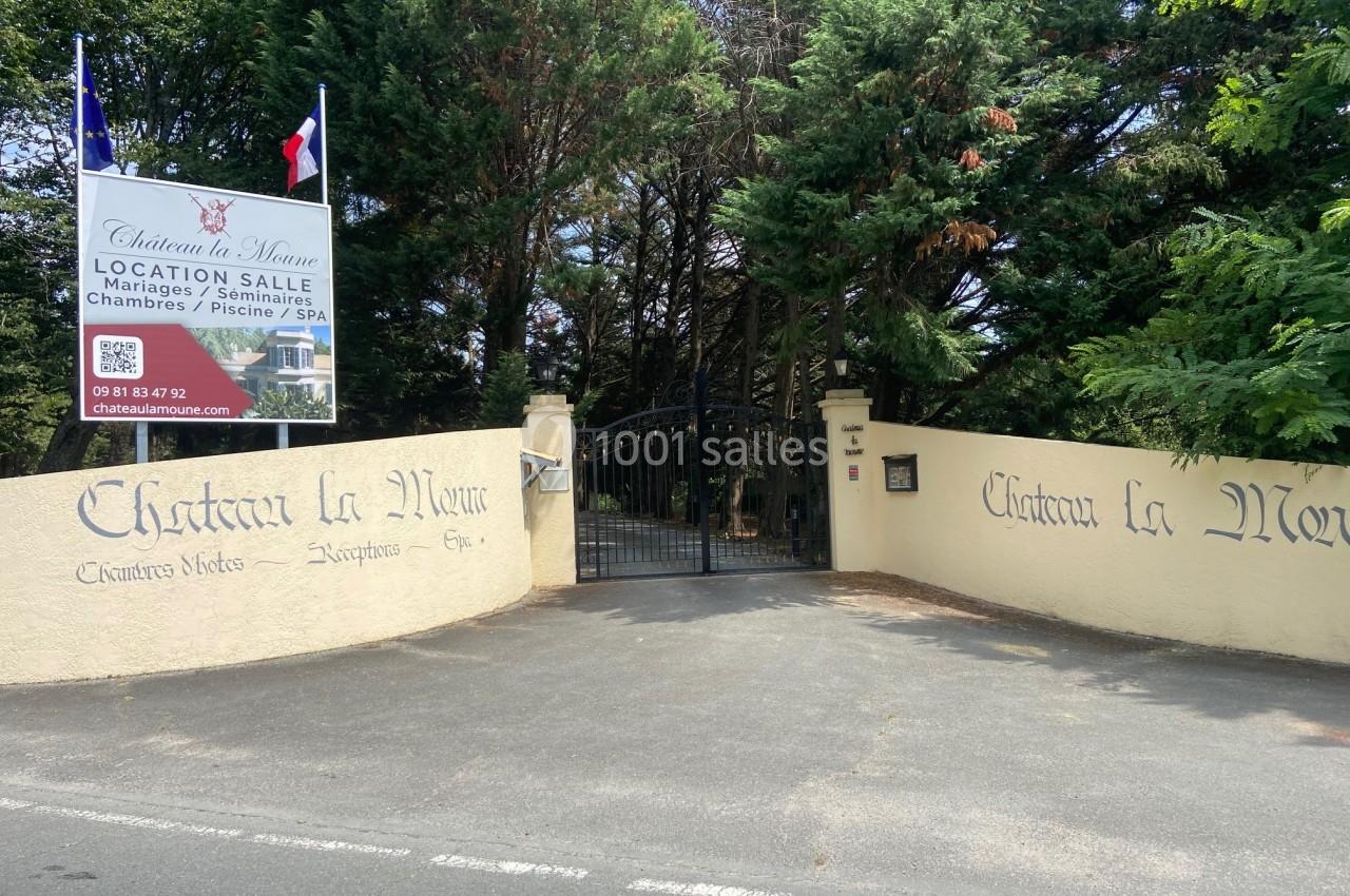 Entrée d'un domaine avec portail noir, murs en pierre gravés ’Château la Moinie’ et panneau d'informations.