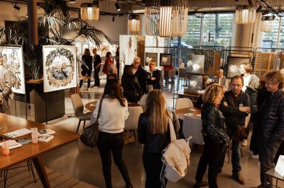 Un café moderne avec un comptoir en bois, des tabourets, des clients et des baristas en pleine discussion.