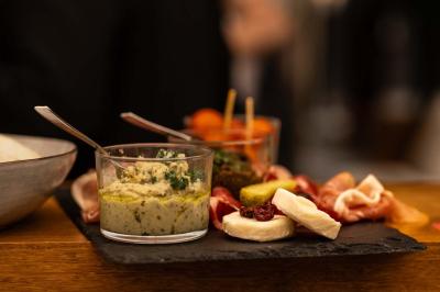 Un café moderne avec un comptoir en bois, des tabourets, des clients et des baristas en pleine discussion.