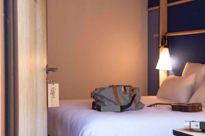 Bureau en bois avec lampe, ordinateur portable et étagères, situé entre deux portes dans une chambre lumineuse.