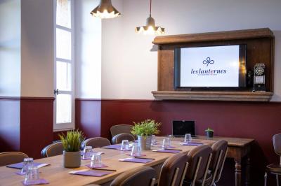 Salon chaleureux avec cheminée allumée, table basse garnie de boissons et snacks, entourée de fauteuils et étagères de…