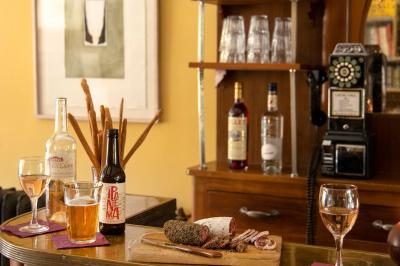 Salon chaleureux avec cheminée allumée, table basse garnie de boissons et snacks, entourée de fauteuils et étagères de…