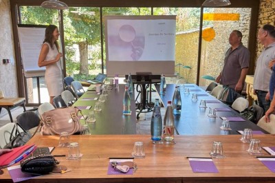 Salon chaleureux avec cheminée allumée, table basse garnie de boissons et snacks, entourée de fauteuils et étagères de…