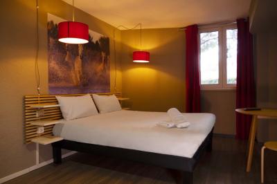 Espace lounge avec fauteuils modernes, tables basses en bois et mur décoré d'une image d'échiquier.