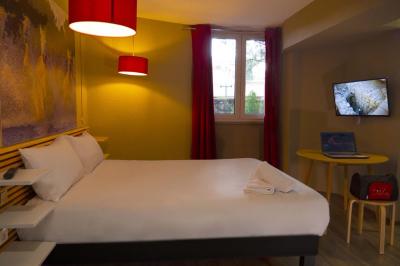 Espace lounge avec fauteuils modernes, tables basses en bois et mur décoré d'une image d'échiquier.