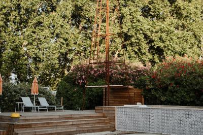 Cour intérieure avec murs recouverts de lierre, une porte en bois ouverte, un tonneau et une lanterne suspendue.