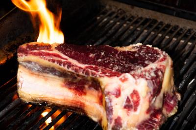 Assiette contenant un poisson entier grillé, des légumes rôtis variés et une sauce servie sur une table en marbre.
