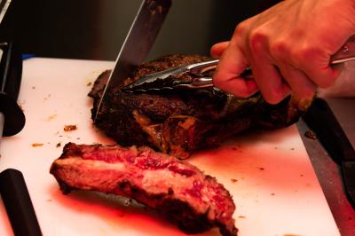 Assiette contenant un poisson entier grillé, des légumes rôtis variés et une sauce servie sur une table en marbre.