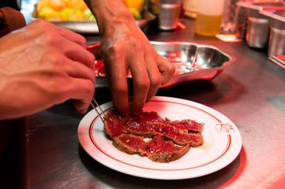 Assiette contenant un poisson entier grillé, des légumes rôtis variés et une sauce servie sur une table en marbre.