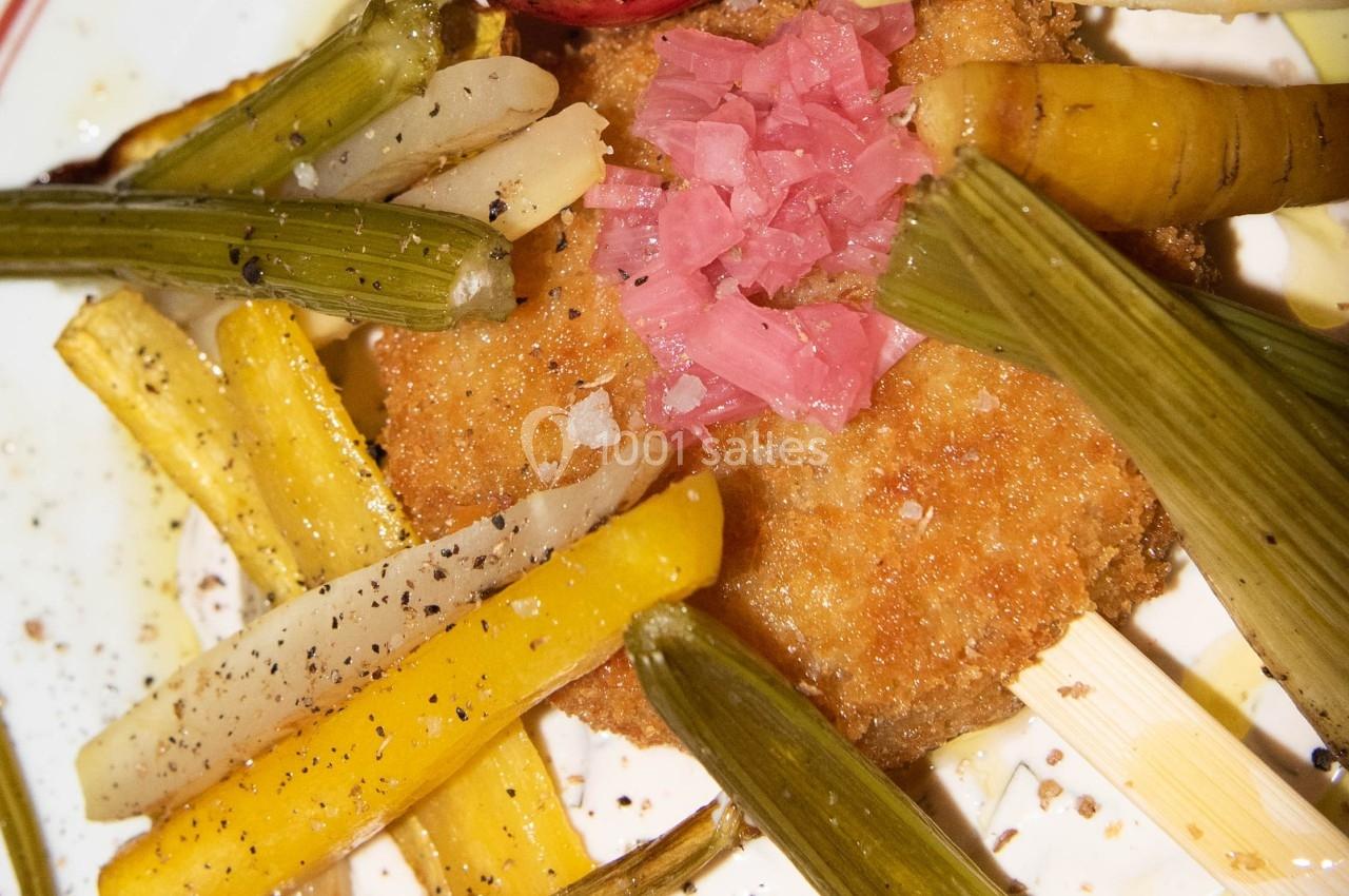 Assiette garnie de légumes grillés et marinés entourant une croquette dorée, servie sur une assiette blanche.