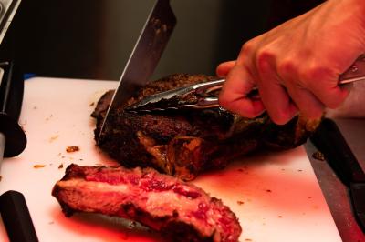 Des personnes assises à des tables dans un restaurant lumineux, discutant et partageant un repas près de grandes fenêtres.