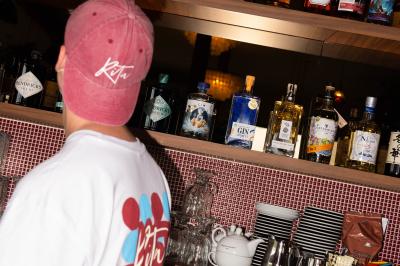 Des personnes assises à des tables dans un restaurant lumineux, discutant et partageant un repas près de grandes fenêtres.