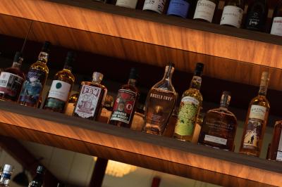 Des personnes assises à des tables dans un restaurant lumineux, discutant et partageant un repas près de grandes fenêtres.