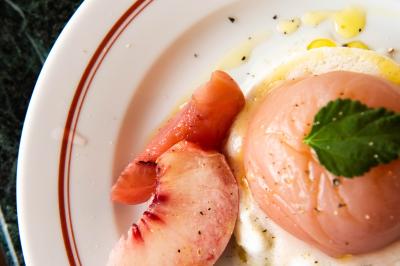 Des personnes assises à des tables dans un restaurant lumineux, discutant et partageant un repas près de grandes fenêtres.