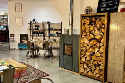 Tables hautes noires dans une salle avec un mur décoré d'une photo de voiture de course vintage.