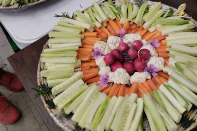 Plateau en bois avec verrines garnies, bol de pain tranché et bouteille de vin mousseux en arrière-plan.
