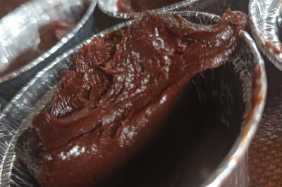 Plateau en bois avec verrines garnies, bol de pain tranché et bouteille de vin mousseux en arrière-plan.