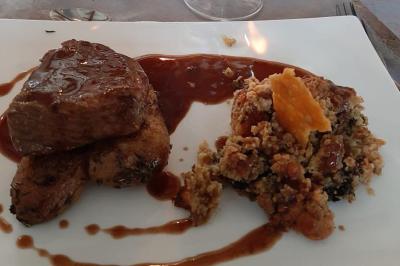 Plateau en bois avec verrines garnies, bol de pain tranché et bouteille de vin mousseux en arrière-plan.