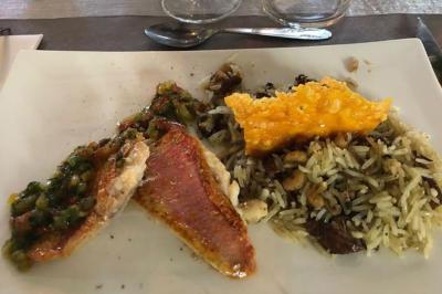 Plateau en bois avec verrines garnies, bol de pain tranché et bouteille de vin mousseux en arrière-plan.