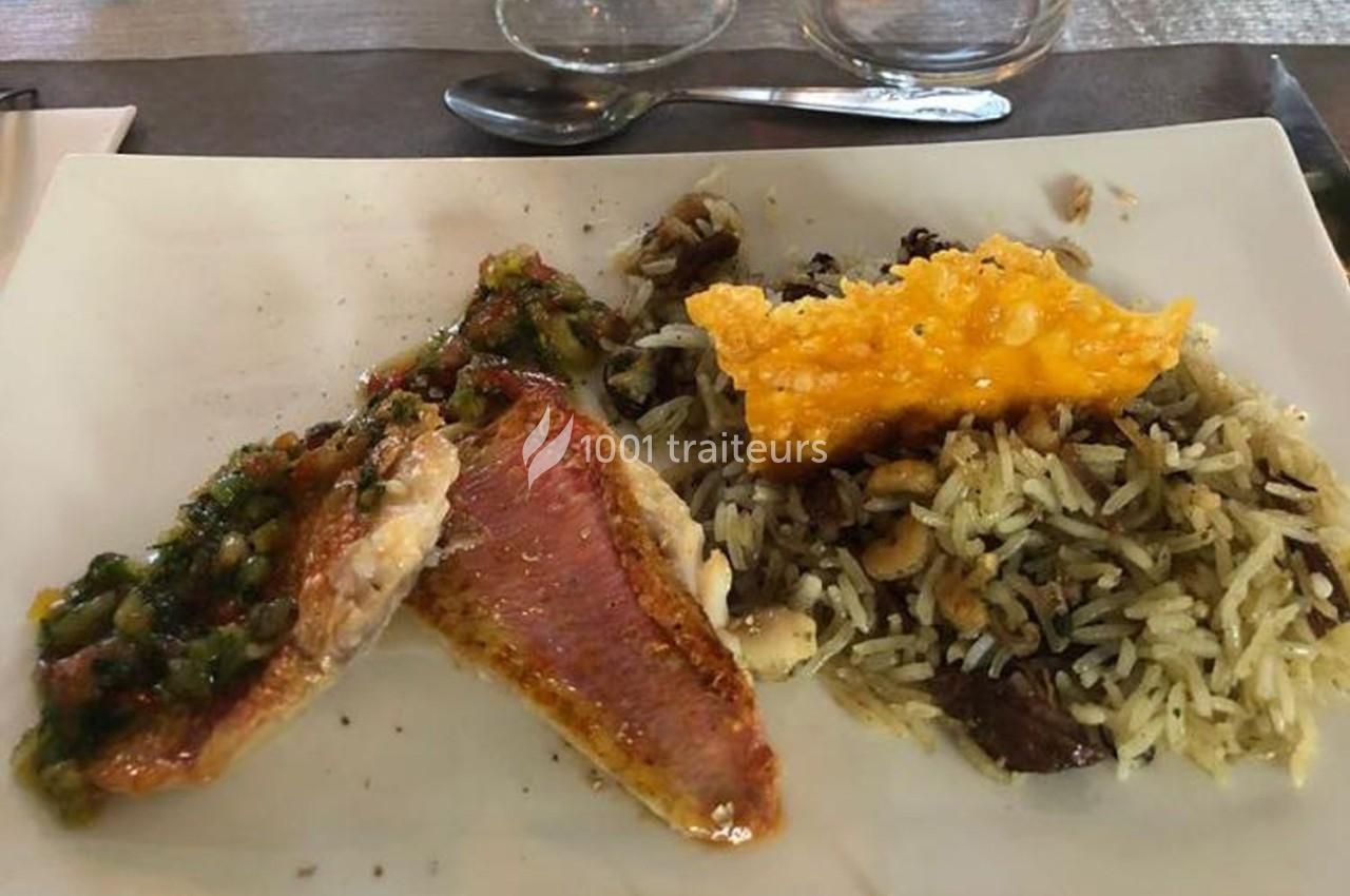 Assiette contenant du poisson grillé avec une sauce, du riz aux champignons et une tuile de fromage croustillante.