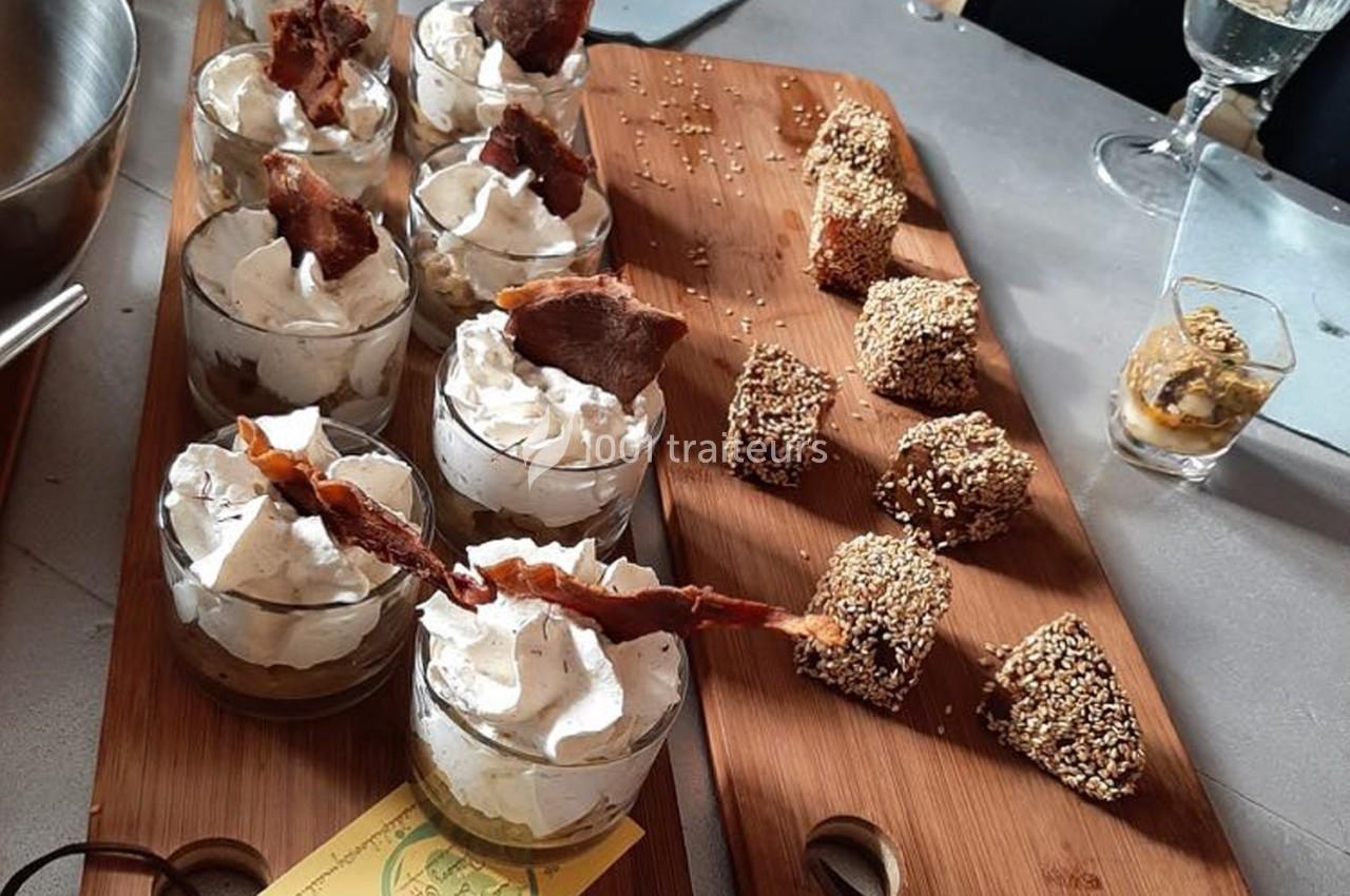 Desserts variés présentés sur des planches en bois, incluant verrines à la crème et bouchées enrobées de graines de sésame.