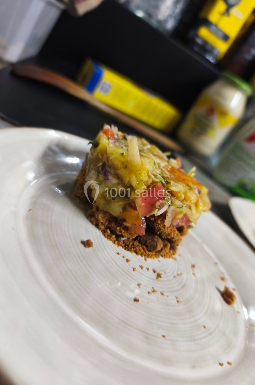 Un plat dressé sur une assiette blanche, composé de légumes colorés sur une base croustillante.