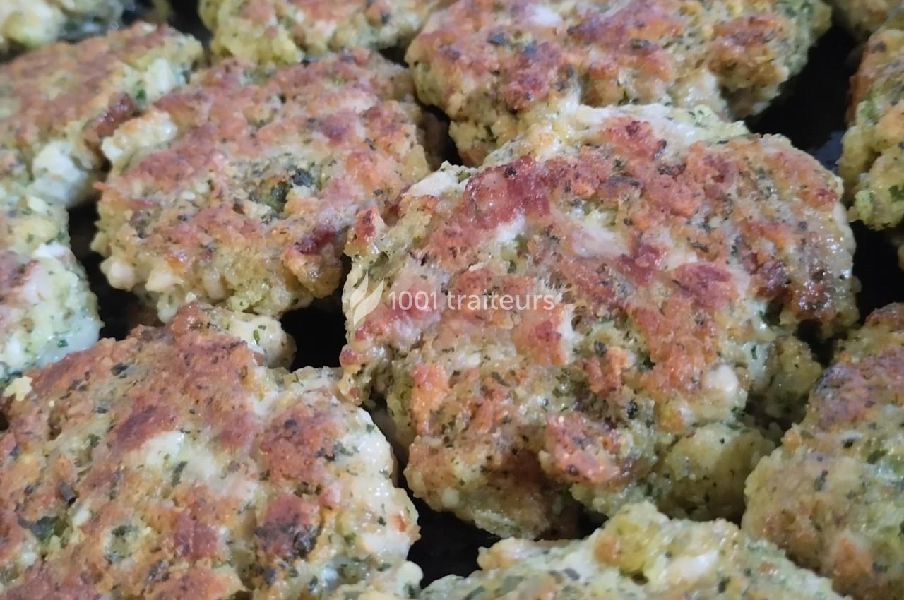 Galettes dorées à base de légumes et d'herbes, disposées côte à côte sur une surface sombre.