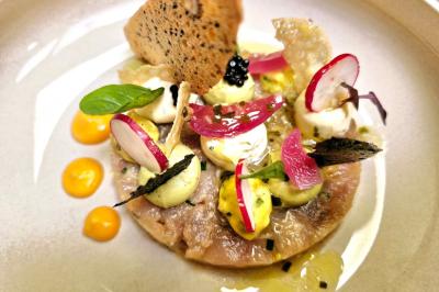 Plat gastronomique composé de viande, légumes, champignons, sauce caramélisée et croustillant sur une assiette décorative.