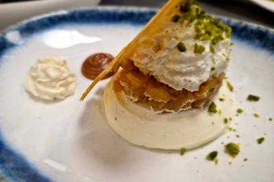 Plat gastronomique composé de viande, légumes, champignons, sauce caramélisée et croustillant sur une assiette décorative.