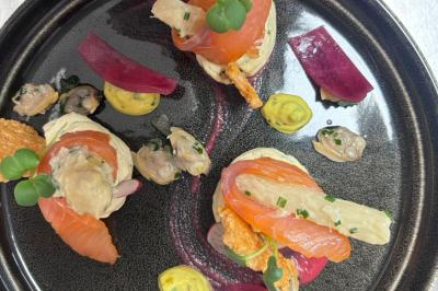 Plat gastronomique composé de viande, légumes, champignons, sauce caramélisée et croustillant sur une assiette décorative.